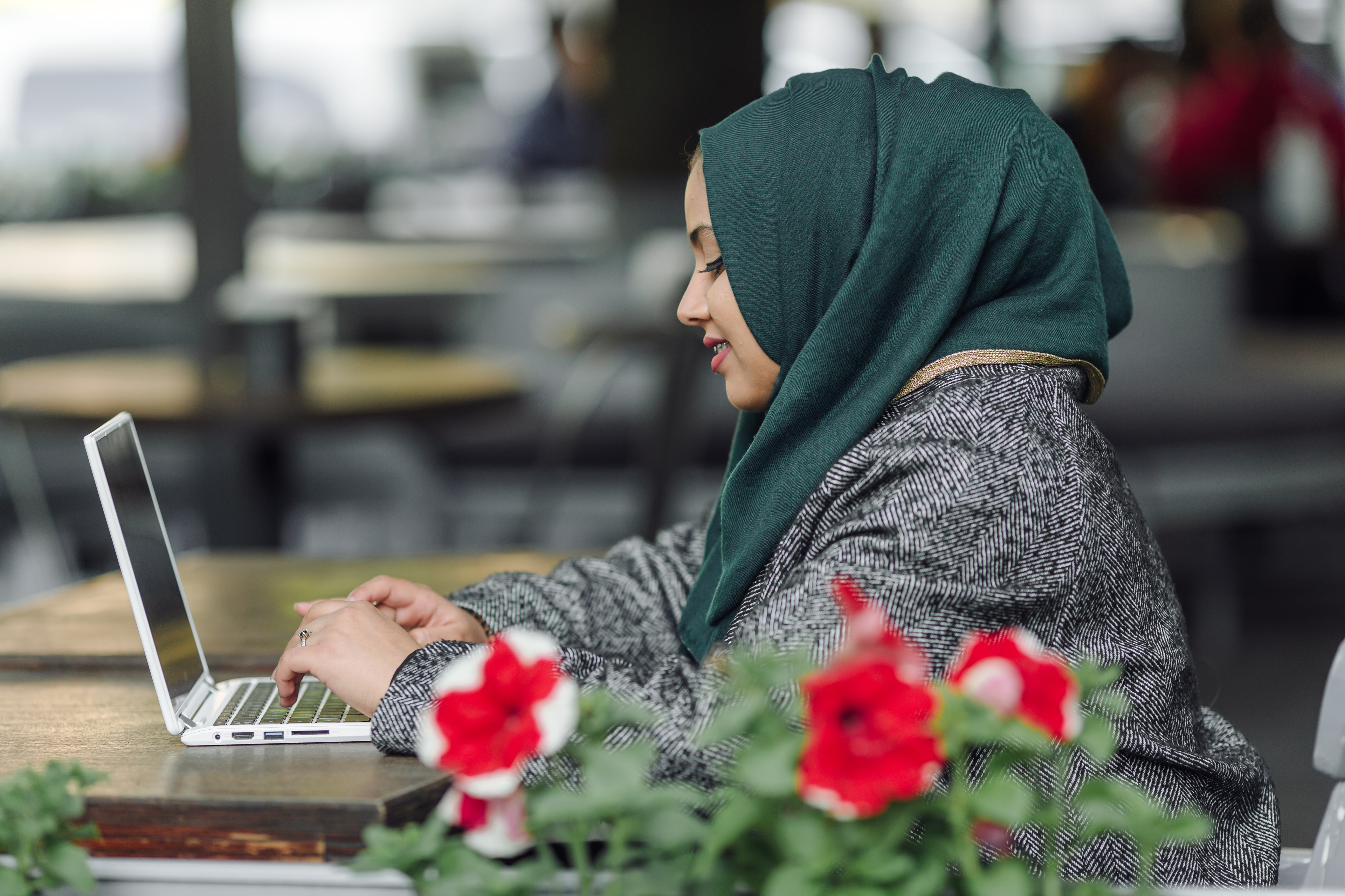 Young Afghan woman reading in a library surrounded by candlelight